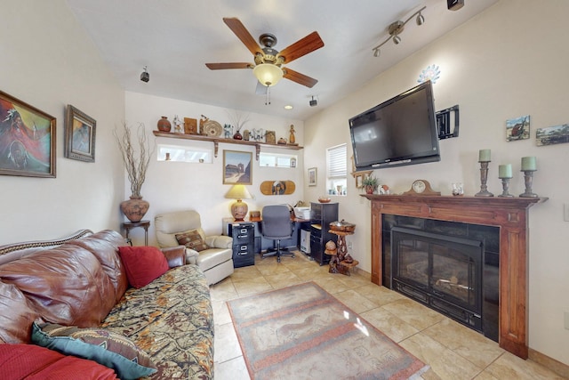 living room featuring a ceiling fan, a glass covered fireplace, track lighting, and tile patterned floors