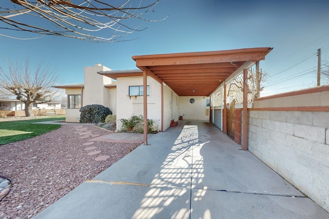 view of patio / terrace with an attached carport and fence