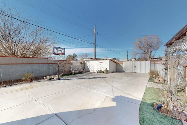 view of patio with a shed, an outdoor structure, a fenced backyard, and a gate