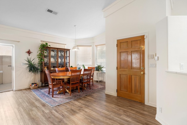 dining room featuring wood finished floors, visible vents, and baseboards