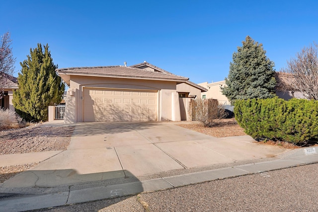 view of front of property with stucco siding, a garage, concrete driveway, and fence