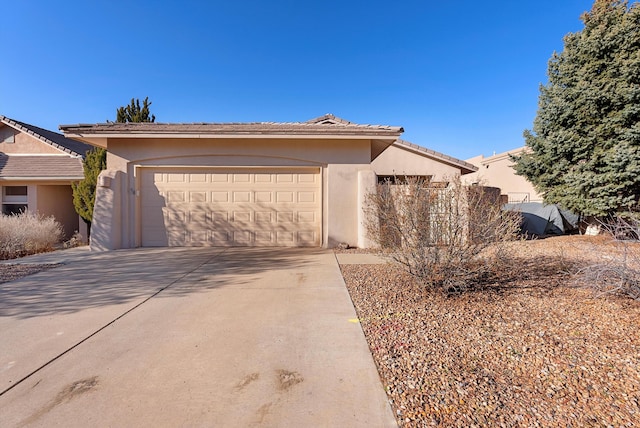 view of front of home with stucco siding, a garage, concrete driveway, and a tile roof