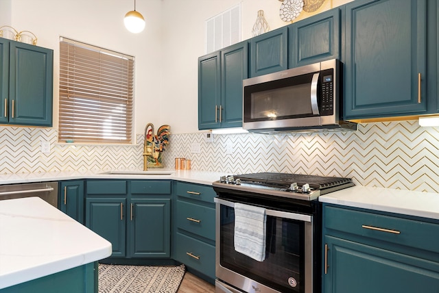 kitchen with visible vents, a sink, tasteful backsplash, appliances with stainless steel finishes, and light countertops