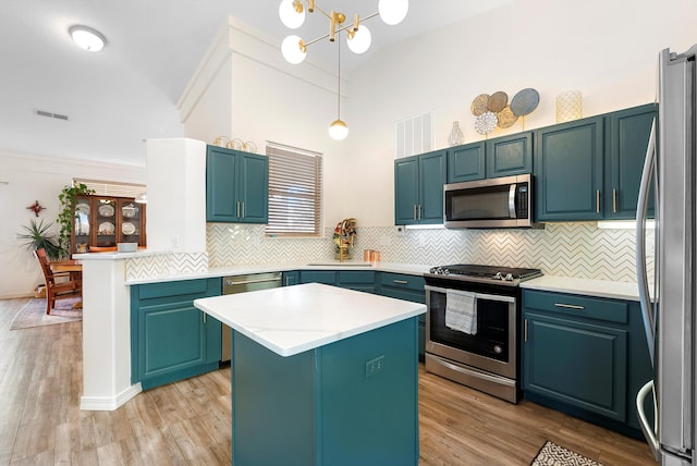 kitchen featuring visible vents, light wood-style flooring, appliances with stainless steel finishes, backsplash, and a center island