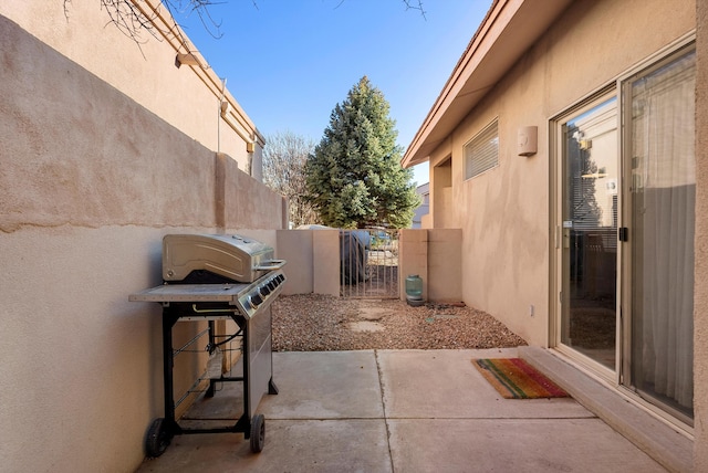 view of patio / terrace with area for grilling, fence, and a gate