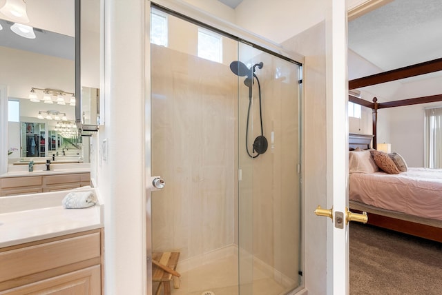 ensuite bathroom featuring vanity, a shower stall, and connected bathroom