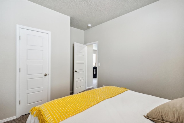 bedroom featuring a textured ceiling, baseboards, and carpet flooring