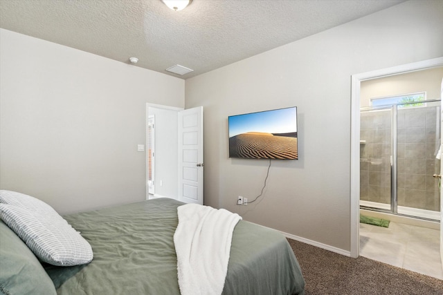 carpeted bedroom featuring a textured ceiling, baseboards, and ensuite bathroom