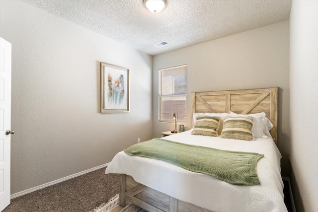 carpeted bedroom featuring a textured ceiling, visible vents, and baseboards