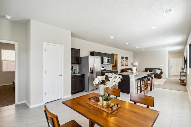 dining space with recessed lighting, visible vents, light tile patterned flooring, a textured ceiling, and baseboards