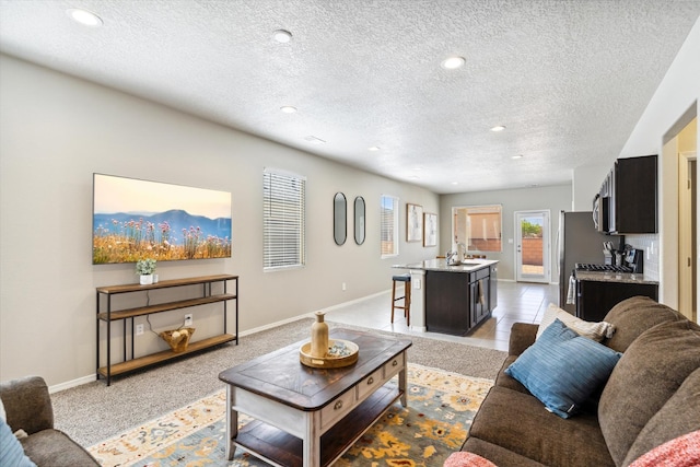 living area with a textured ceiling, recessed lighting, and baseboards