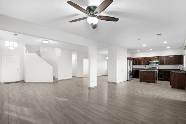 interior space with open floor plan, stainless steel appliances, a kitchen island, and visible vents