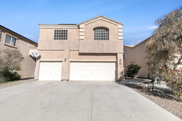 view of front of house featuring a garage, concrete driveway, and stucco siding