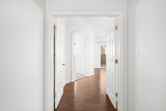 hallway with baseboards and wood finished floors