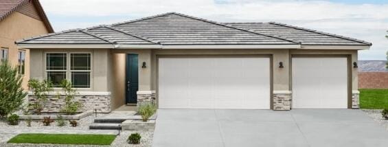 view of front of house with concrete driveway, a tiled roof, and stucco siding