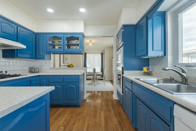 kitchen with blue cabinetry, light countertops, a sink, black gas stovetop, and dishwasher