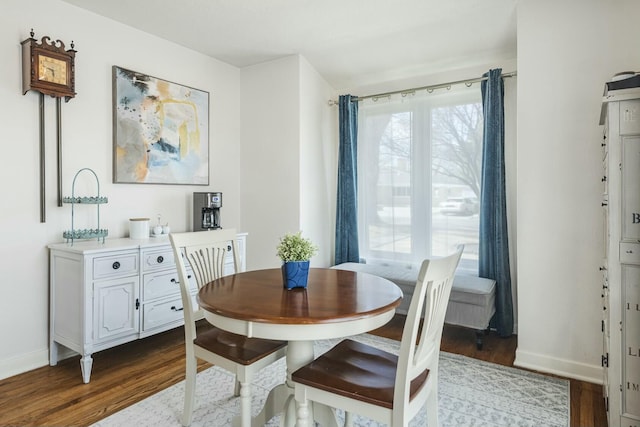 dining space with dark wood finished floors and baseboards