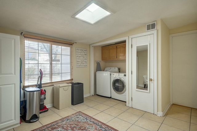 clothes washing area featuring cabinet space, light tile patterned floors, visible vents, and independent washer and dryer