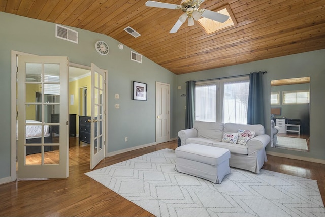 living room with lofted ceiling with skylight, visible vents, and french doors