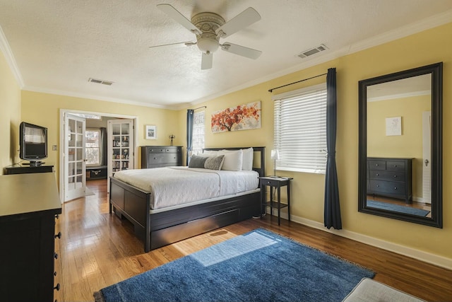 bedroom featuring ornamental molding, hardwood / wood-style flooring, and visible vents