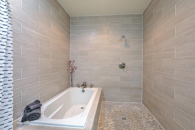 full bathroom featuring a tile shower and a bath