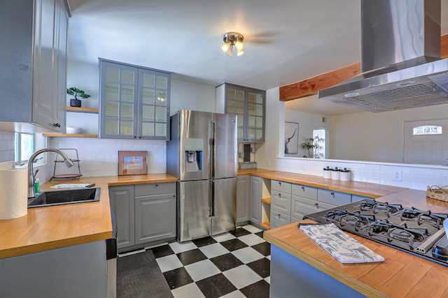 kitchen with dark floors, a sink, wood counters, ventilation hood, and stainless steel refrigerator with ice dispenser