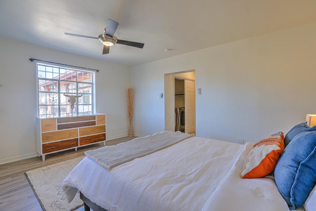 bedroom featuring ceiling fan, light wood-type flooring, and baseboards