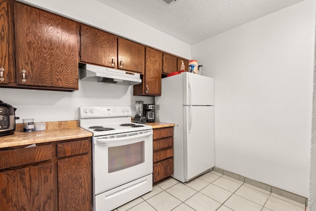 kitchen with under cabinet range hood, white appliances, a textured ceiling, and light countertops