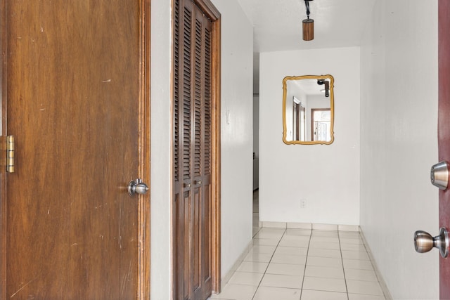 hall with tile patterned flooring and baseboards