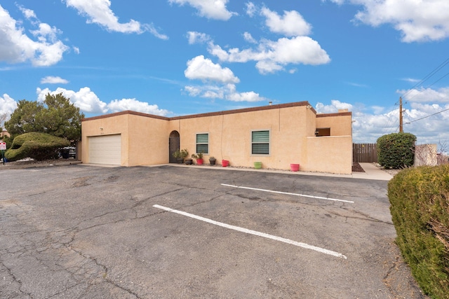 view of building exterior featuring uncovered parking and fence