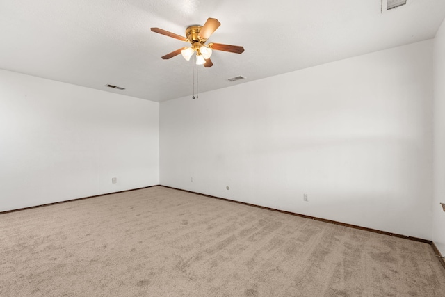 unfurnished room featuring carpet floors, visible vents, and a ceiling fan