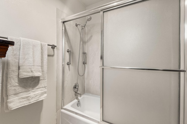 bathroom featuring combined bath / shower with glass door