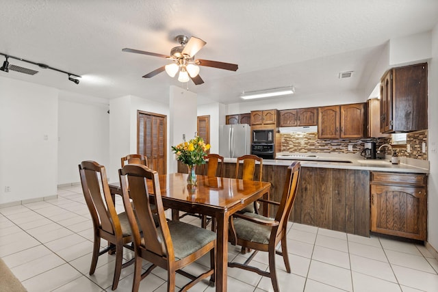 dining room with light tile patterned floors, visible vents, a ceiling fan, and a textured ceiling