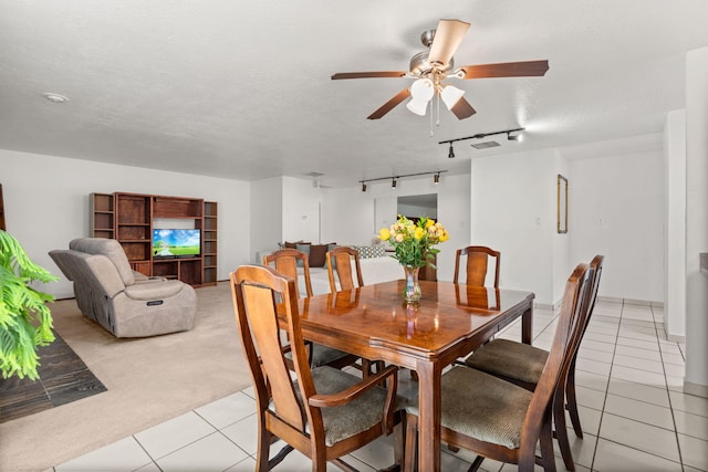 dining area with a textured ceiling, light tile patterned flooring, light carpet, a ceiling fan, and rail lighting