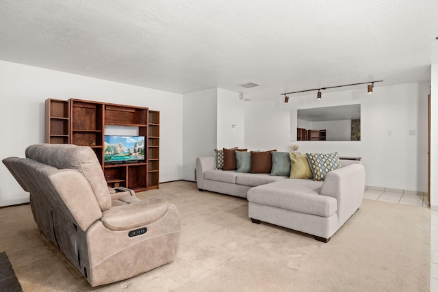 living area featuring track lighting, visible vents, and a textured ceiling