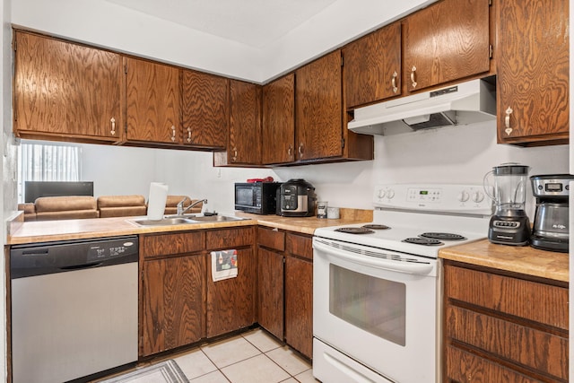 kitchen with under cabinet range hood, electric range, a sink, light countertops, and stainless steel dishwasher