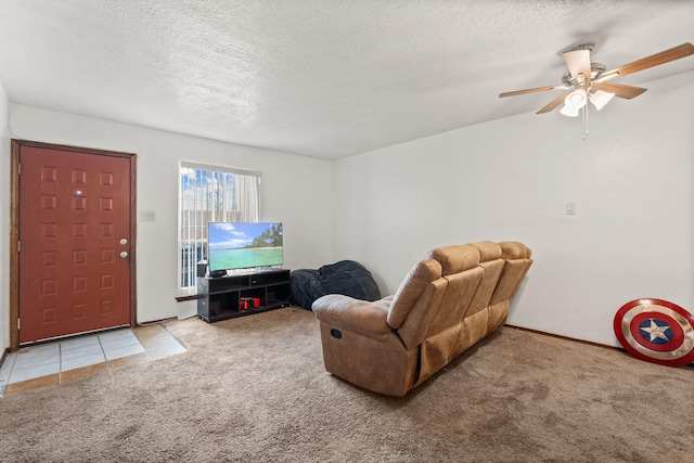 living area with a ceiling fan, carpet, and a textured ceiling