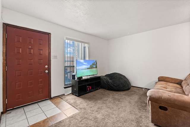 foyer with light carpet, a textured ceiling, and light tile patterned floors