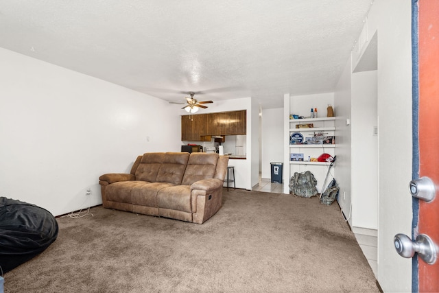 carpeted living room with a textured ceiling and ceiling fan