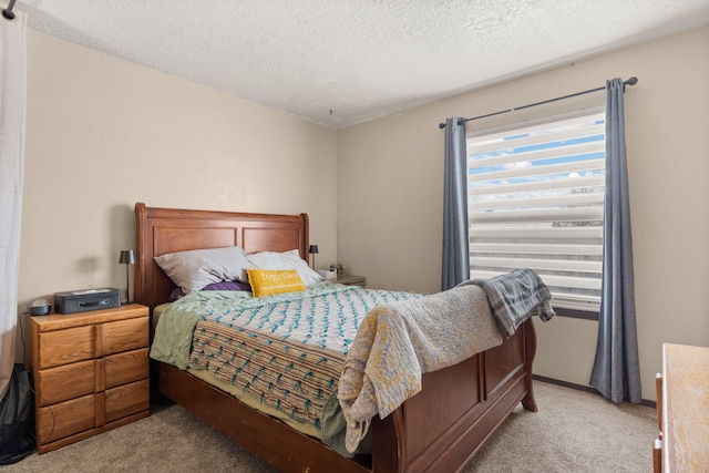 bedroom with light carpet and a textured ceiling