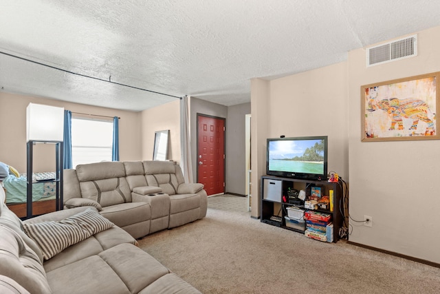 living area with a textured ceiling, carpet floors, visible vents, and baseboards