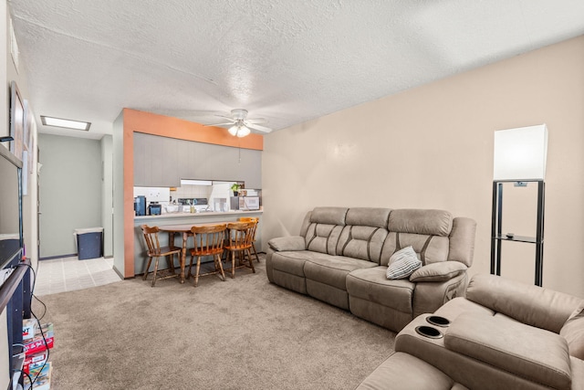 living room featuring ceiling fan, a textured ceiling, and light colored carpet