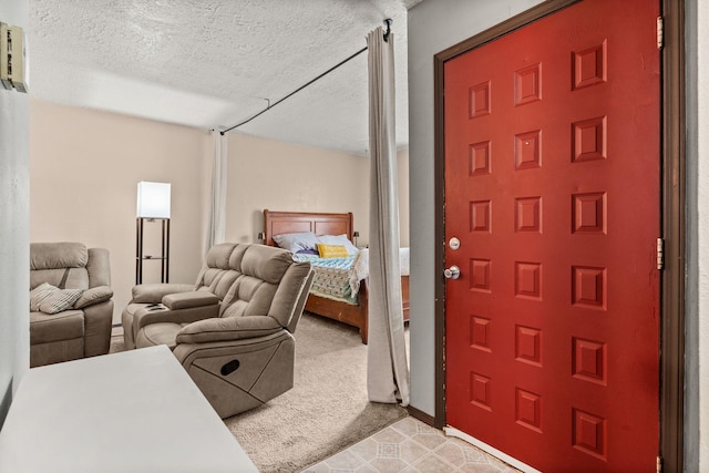 foyer entrance featuring a textured ceiling and light colored carpet