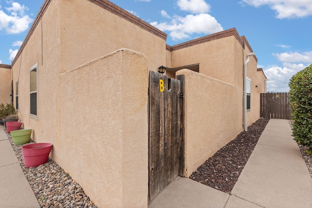 view of home's exterior featuring a gate, fence, and stucco siding