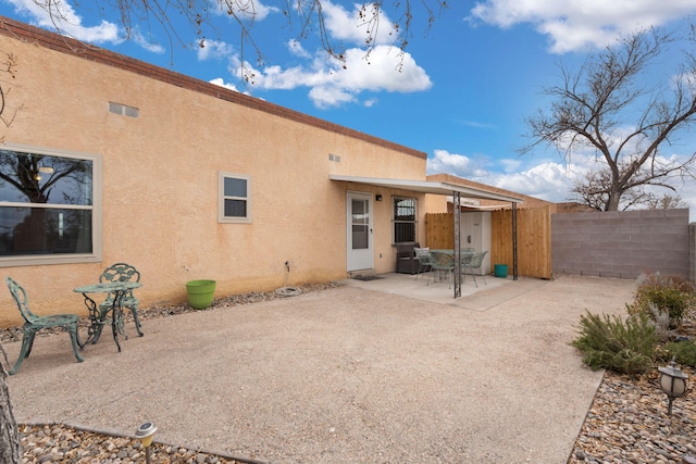 back of property with a patio, fence, and stucco siding