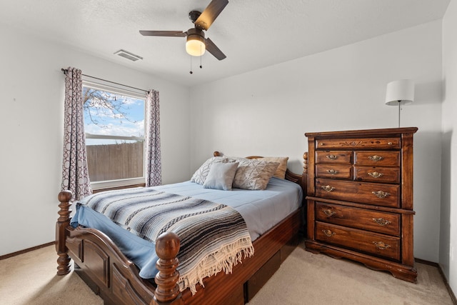 bedroom with baseboards, visible vents, light colored carpet, ceiling fan, and a textured ceiling