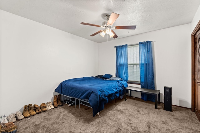 bedroom with carpet floors, a ceiling fan, and a textured ceiling