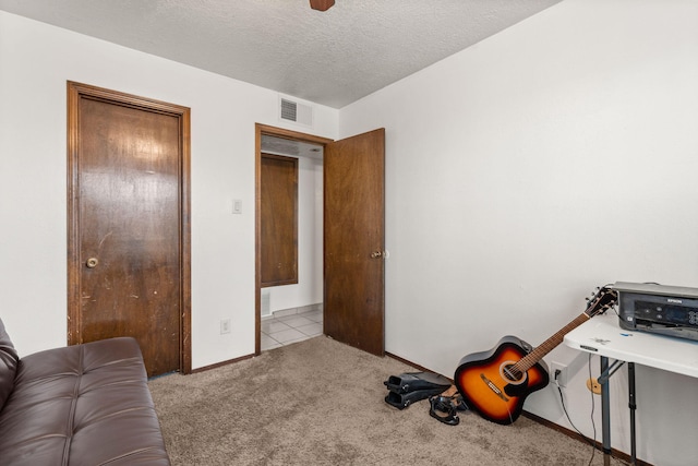 interior space with a textured ceiling, visible vents, and baseboards