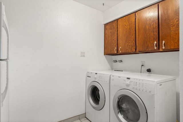 clothes washing area featuring washing machine and clothes dryer and cabinet space