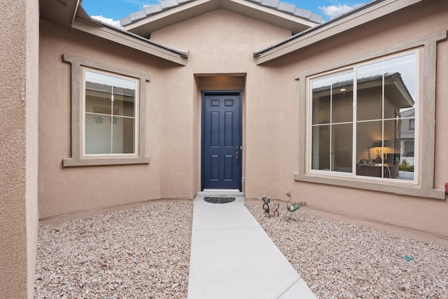 doorway to property featuring stucco siding